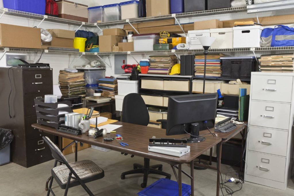 messy office with piles of files and storage boxes