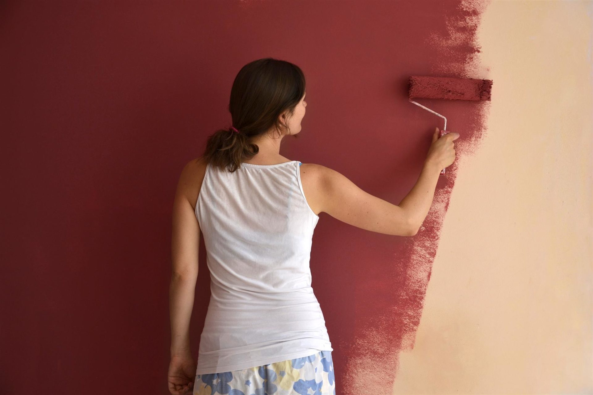 young woman painting wall
